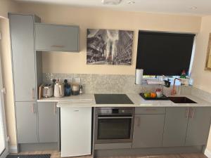 a kitchen with white cabinets and a counter top at Griffin Lodge in Warwick