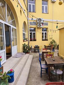 a patio with tables and chairs and a yellow building at ETALON in the heart of Novi Sad in Novi Sad