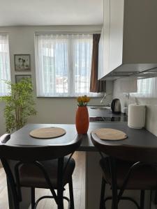 a kitchen with two chairs and a table with a counter at Center apartment in Gnjilane +2 photos