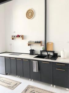 a kitchen with black cabinets and a white counter top at ETALON in the heart of Novi Sad in Novi Sad +8 photos