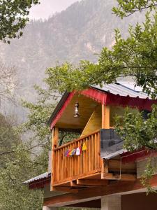 a tree house with a bell on top of it at GhratFalls Stone Cottage in Banjār