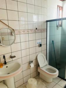 a bathroom with a sink and a toilet and a mirror at Hostel Meu Sossego Vilas in Lauro de Freitas +48 photos