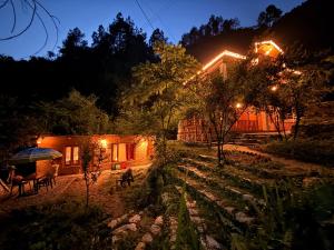 a house at night with a patio and lights at GhratFalls Stone Cottage in Banjār