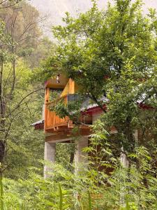 a tree house in the middle of a forest at GhratFalls Stone Cottage in Banjār