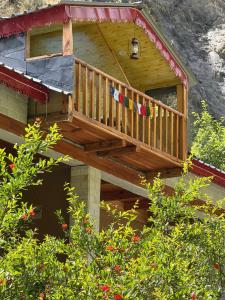 a balcony of a house with flags on it at GhratFalls Stone Cottage in Banjār +30 photos