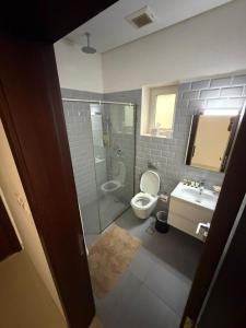 a bathroom with a shower and a toilet and a sink at Hawana Studio in Salalah