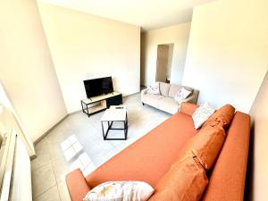 a living room with a couch and a tv at La Rivière Enchantée in Peyraud