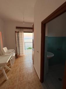 a bathroom with a table and a sink and a tub at Villa Denis Gjeta in Borsh