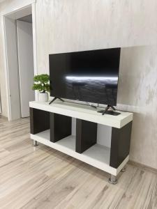a tv on a white stand in a living room at Domaćinstvo Kondić in Podovi