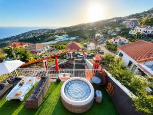 a bath tub sitting on top of a green yard at Ponta do Sol Villa in Ponta do Sol