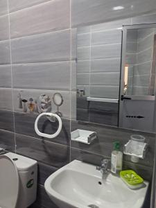 a bathroom with a sink and a mirror and a toilet at mdiq in M'diq