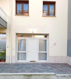 a white door on a white building at Residenza Orchidea in Tarquinia
