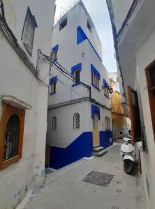 a blue and white building with a scooter parked in a alley at San Marcelo De Tangier in Tangier