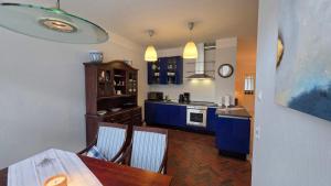 a kitchen with a table and a blue kitchen at Altstadt Zauber in Waren