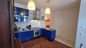a kitchen with blue cabinets and a sink at Altstadt Zauber in Waren
