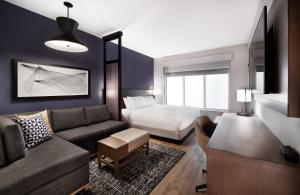 a living room with a couch and a bed at Hyatt Place Waco/Downtown in Waco