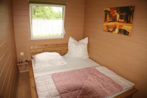 a small bedroom with a bed and a window at Bungalow Seedorf 4 in Basedow