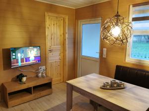 a dining room with a table and a tv at Bungalow Seedorf 7 in Basedow