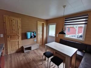 a living room with a table and a television at Bungalow Seedorf 8 in Basedow