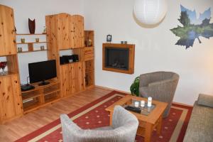 a living room with wooden furniture and a television at Ferienwohnung Seedorf in Basedow