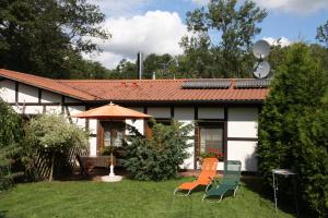 a house with two chairs and an umbrella in the yard at Ferienwohnung Seedorf in Basedow +2 photos