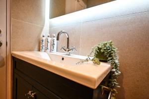 a sink in a bathroom with a light above it at Radnor Rest in Folkestone +13 photos