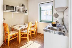 a kitchen with a table and chairs and a sink at Am Müritzer Hafen App 1 in Waren