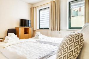 a hotel room with two beds and a tv at Am Müritzer Hafen App 1 in Waren +10 photos