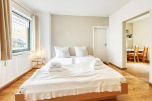 a bedroom with a large white bed with towels on it at Am Müritzer Hafen App 1 in Waren
