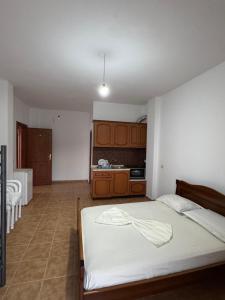 a bedroom with a white bed and a kitchen at Villa Denis Gjeta in Borsh +40 photos