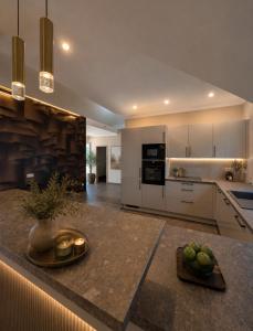 a kitchen with white cabinets and a table with fruit on it at Waldresidenz Lutz in Bad Lippspringe