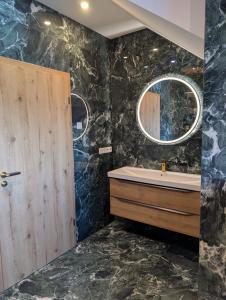 a bathroom with a sink and a tub and a mirror at Waldresidenz Lutz in Bad Lippspringe