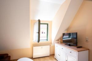 a living room with a tv on a dresser at Am Müritzer Hafen App 4 in Waren