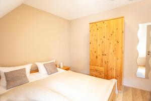 a bedroom with two beds and a wooden cabinet at Am Müritzer Hafen App 4 in Waren