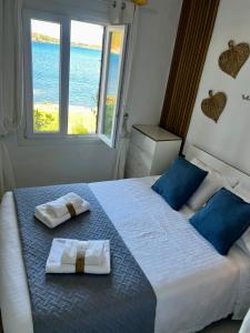ein Schlafzimmer mit einem Bett, auf dem zwei Handtücher liegen in der Unterkunft Miravent Terraza y Jardin Frente al mar Menorca in Fornells