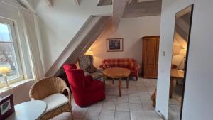 a living room with red chairs and a table at Altstadt Loft in Waren +9 photos
