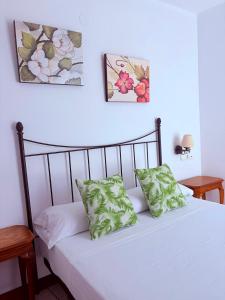 a bedroom with a bed with white sheets and pillows at Hotel Alandalus in Torrox