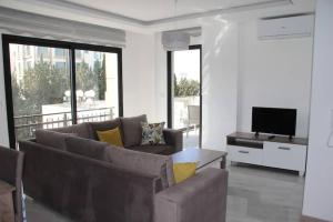 a living room with a couch and a television at Pamfilya Royal Kyrenia B Blok in Kyrenia