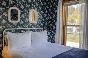 a bedroom with a bed and a floral wall at The Governor's Inn in Ludlow