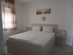 a bed in a white room with at Pogled na more in Pečurice