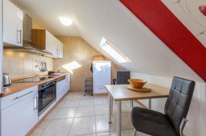 a kitchen with a table and a red and white wall at Ferienwohnung Sonnendeck in Klink