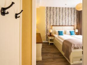 a hotel room with a bed with blue pillows at Hotel Apartment Central Leipzig-City & Zoo in Leipzig