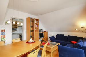 a living room with a blue couch and a table at Ferienwohnung Argenpark Kressbronn in Kressbronn am Bodensee +12 photos