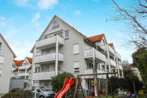 a apartment building with a playground in front of it at Ferienwohnung Argenpark Kressbronn in Kressbronn am Bodensee