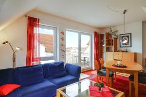 a living room with a blue couch and a table at Ferienwohnung Argenpark Kressbronn in Kressbronn am Bodensee