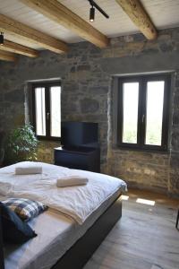 a bedroom with a large bed in a stone wall at Viktor Estate in Deskle