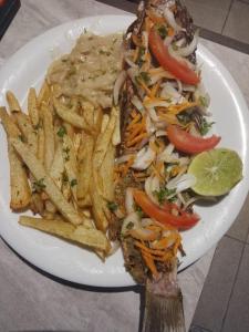a plate of food with a sandwich and french fries at Kalis Hotel in Douala