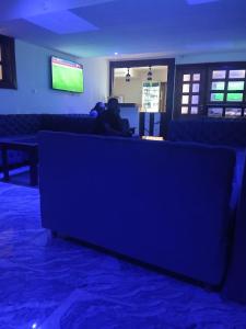 a person sitting on a couch in a living room at Kalis Hotel in Douala