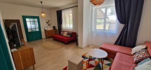 a living room with a red couch and a tv at Dãnu Guesthouse in Kravany nad Dunajom