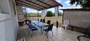 a table and chairs on a patio with a view at Dãnu Guesthouse in Kravany nad Dunajom